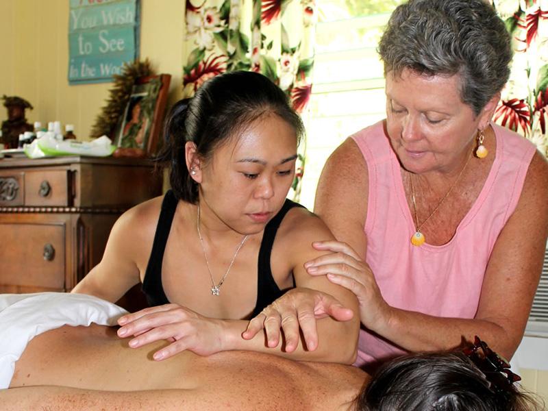 Carol Hart helping a student learn Mana Lomi massage technique
