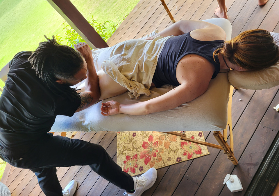 Man doing a Mana Lomi massage on a woman in Hawaii