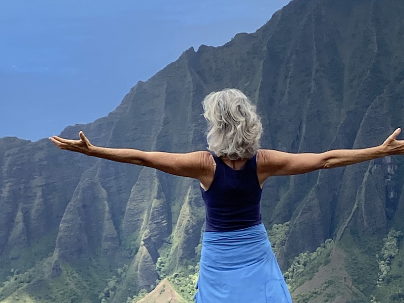 Woman with outstretched arms in the mountains of Kauai